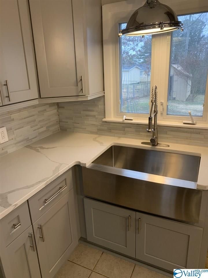 A kitchen with a stainless steel sink and a window.