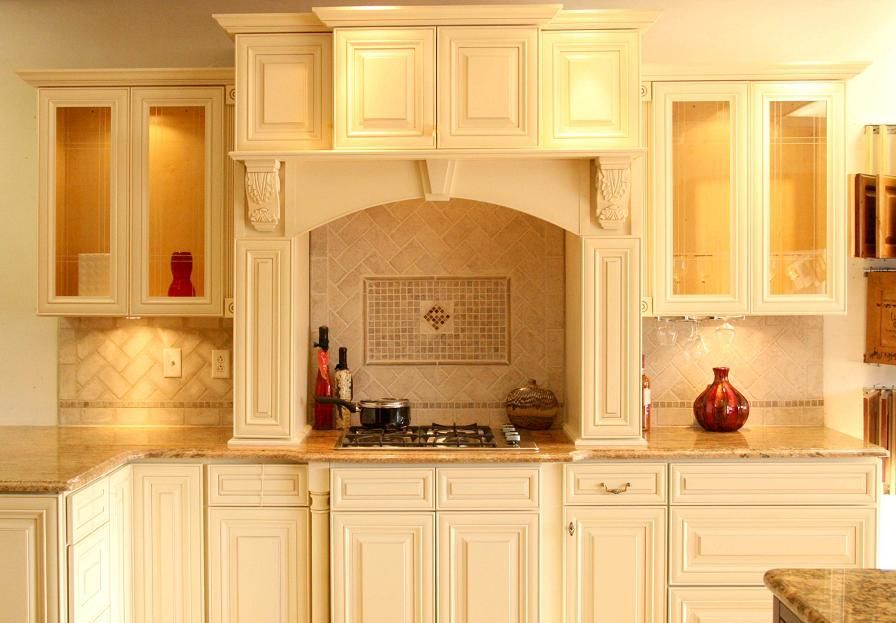 A kitchen with white cabinets and a stove top oven.