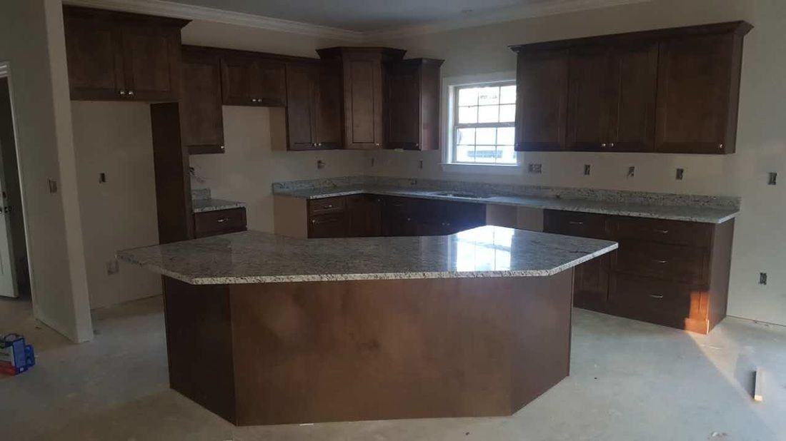 An empty kitchen with a large island in the middle