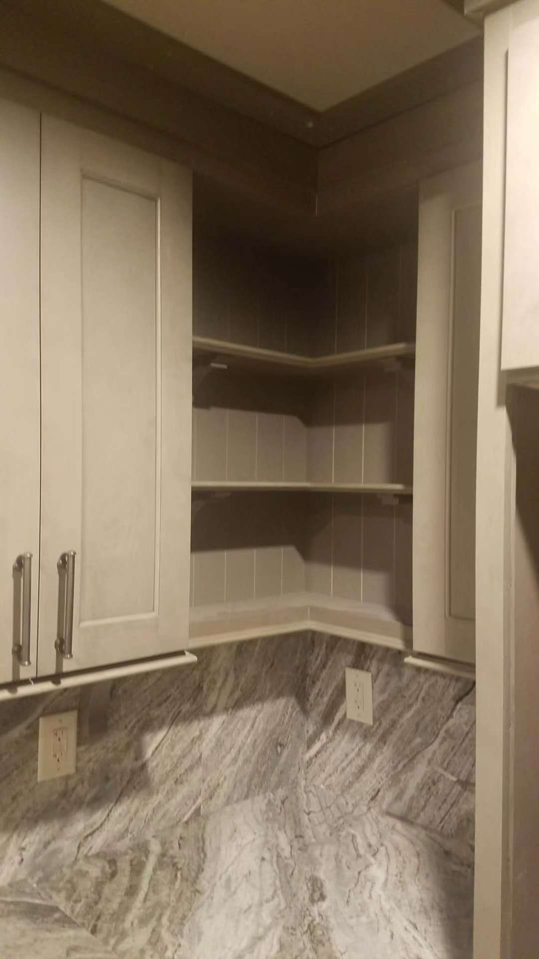 A kitchen with white cabinets and granite counter tops.