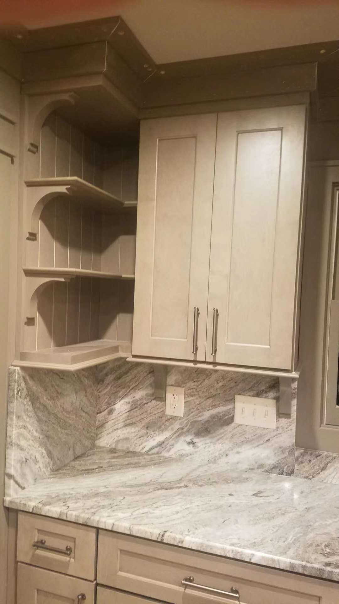 A kitchen with white cabinets and granite counter tops.