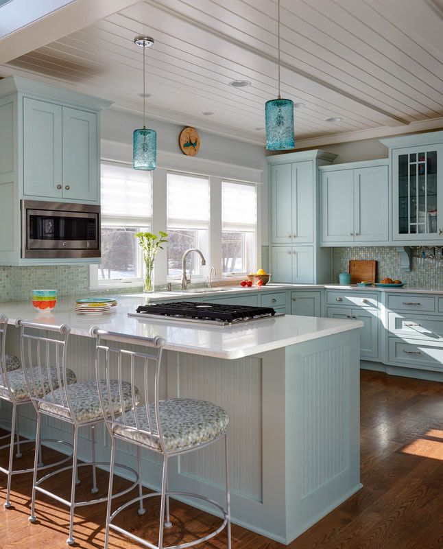 A kitchen with light blue cabinets and a large island