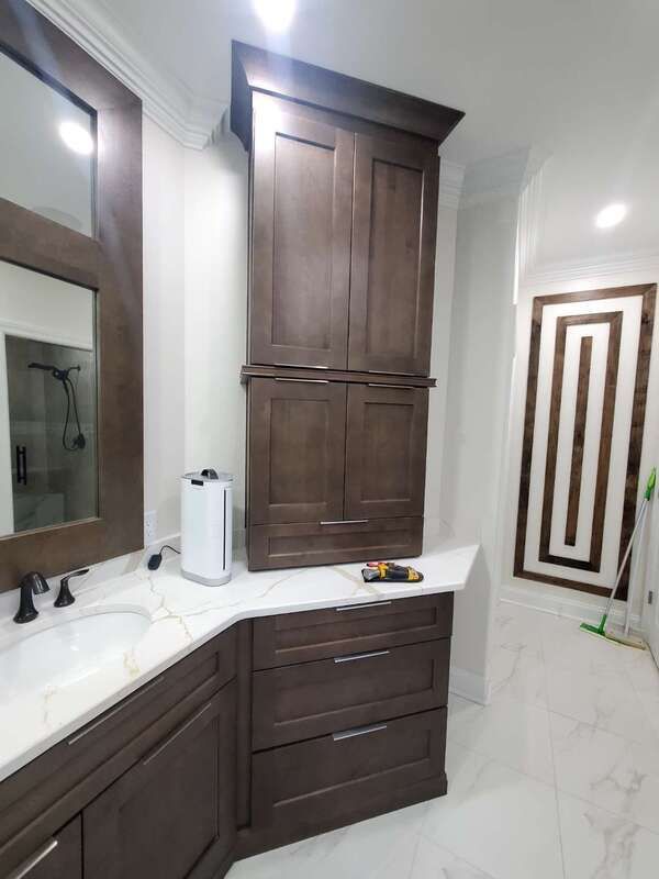 A bathroom with a sink , cabinets and a mirror