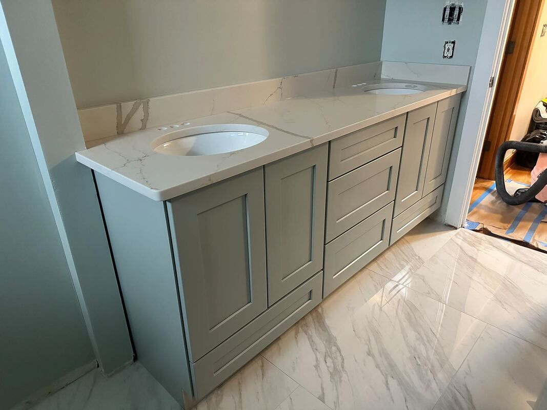 A bathroom vanity with two sinks and a marble floor.