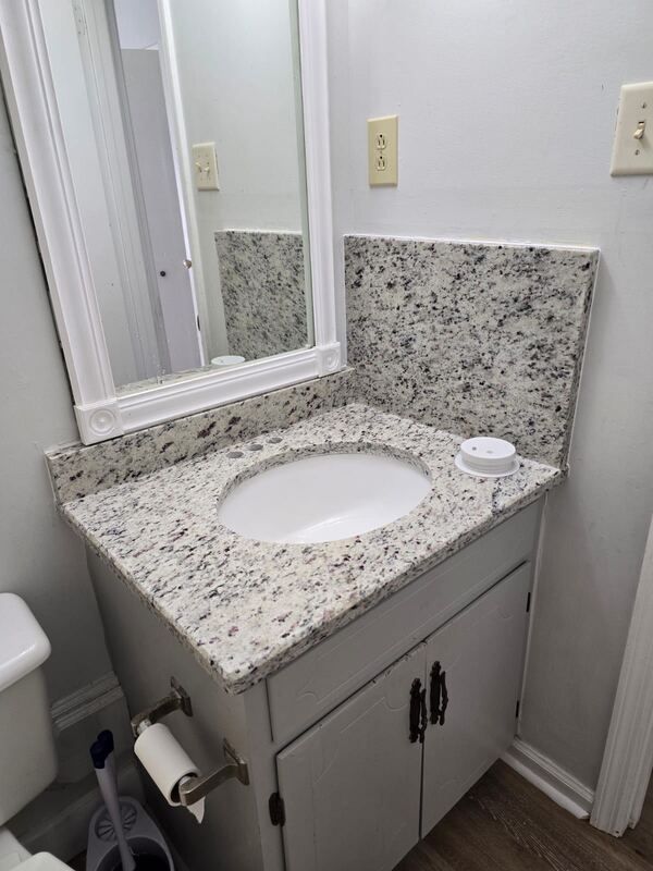 A bathroom with a sink , mirror and toilet.