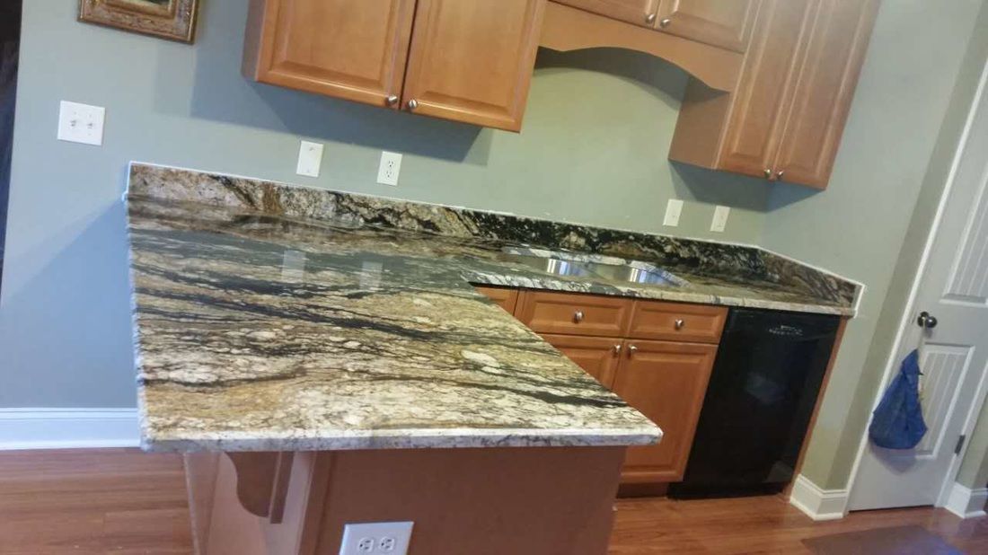 A kitchen with a granite counter top and wooden cabinets.