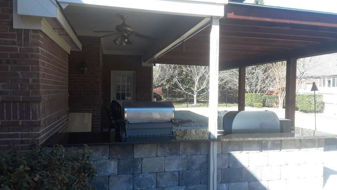 A brick house with a covered porch and a grill.