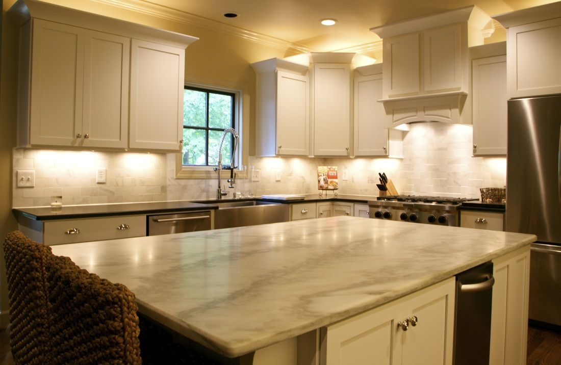A kitchen with white cabinets and stainless steel appliances
