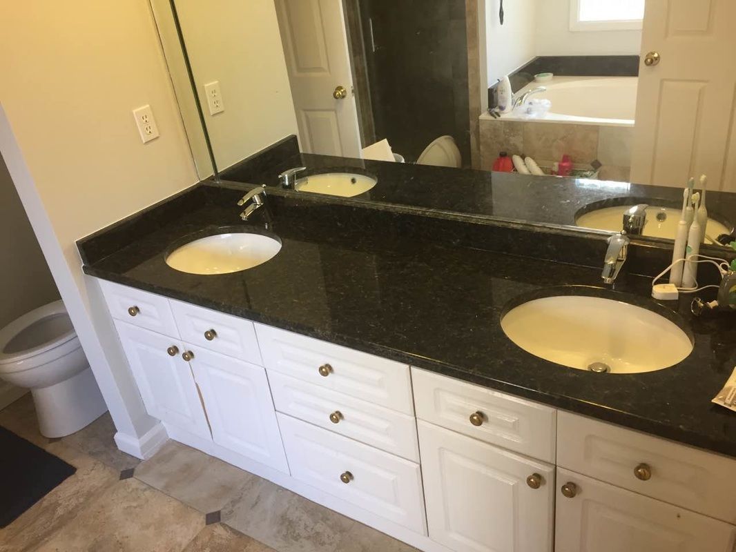 A bathroom with two sinks and a large mirror.