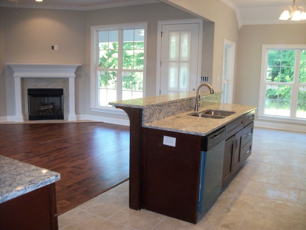 An empty kitchen with a sink and a fireplace