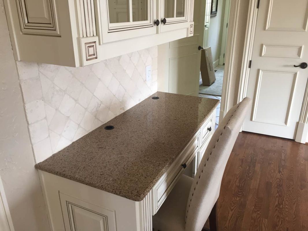 A desk with a chair underneath it in a kitchen.