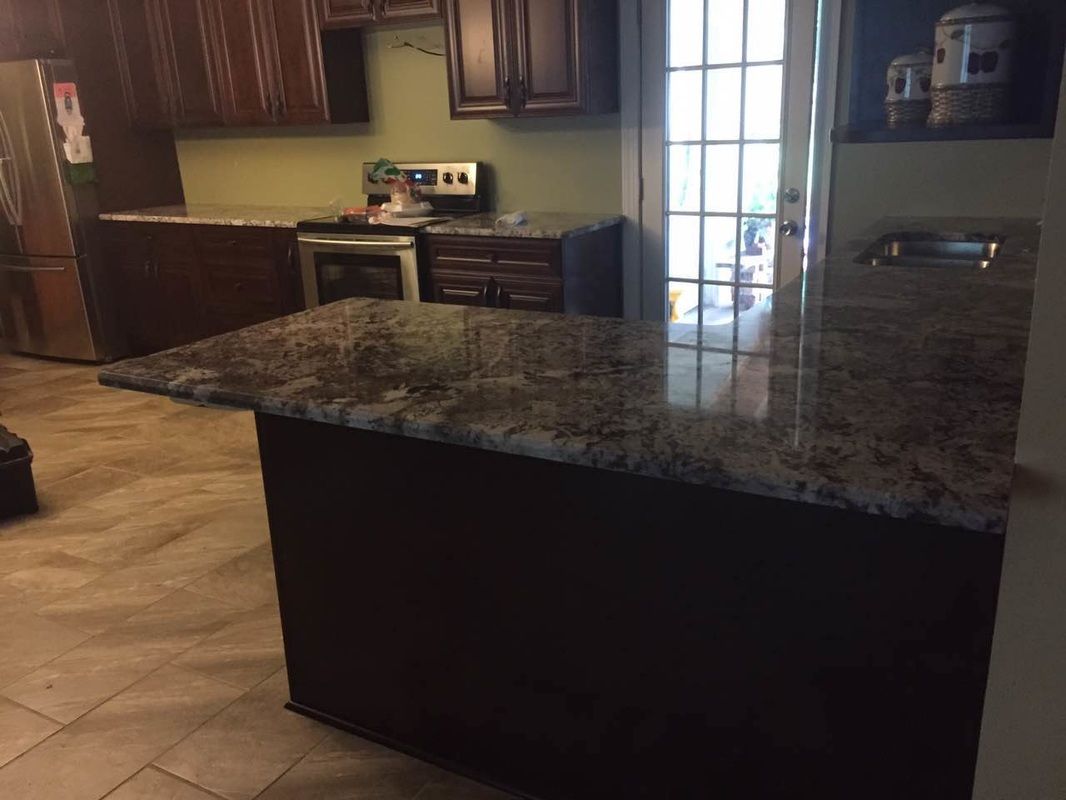 A kitchen with a large granite counter top