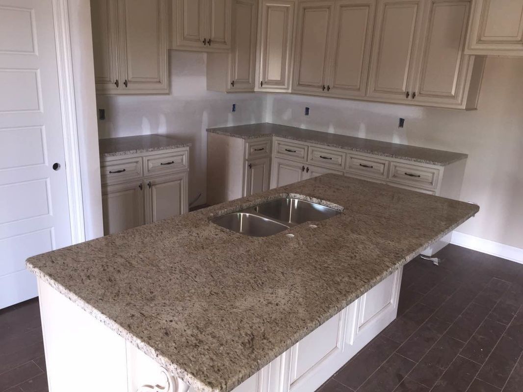 A kitchen with granite counter tops and stainless steel sinks