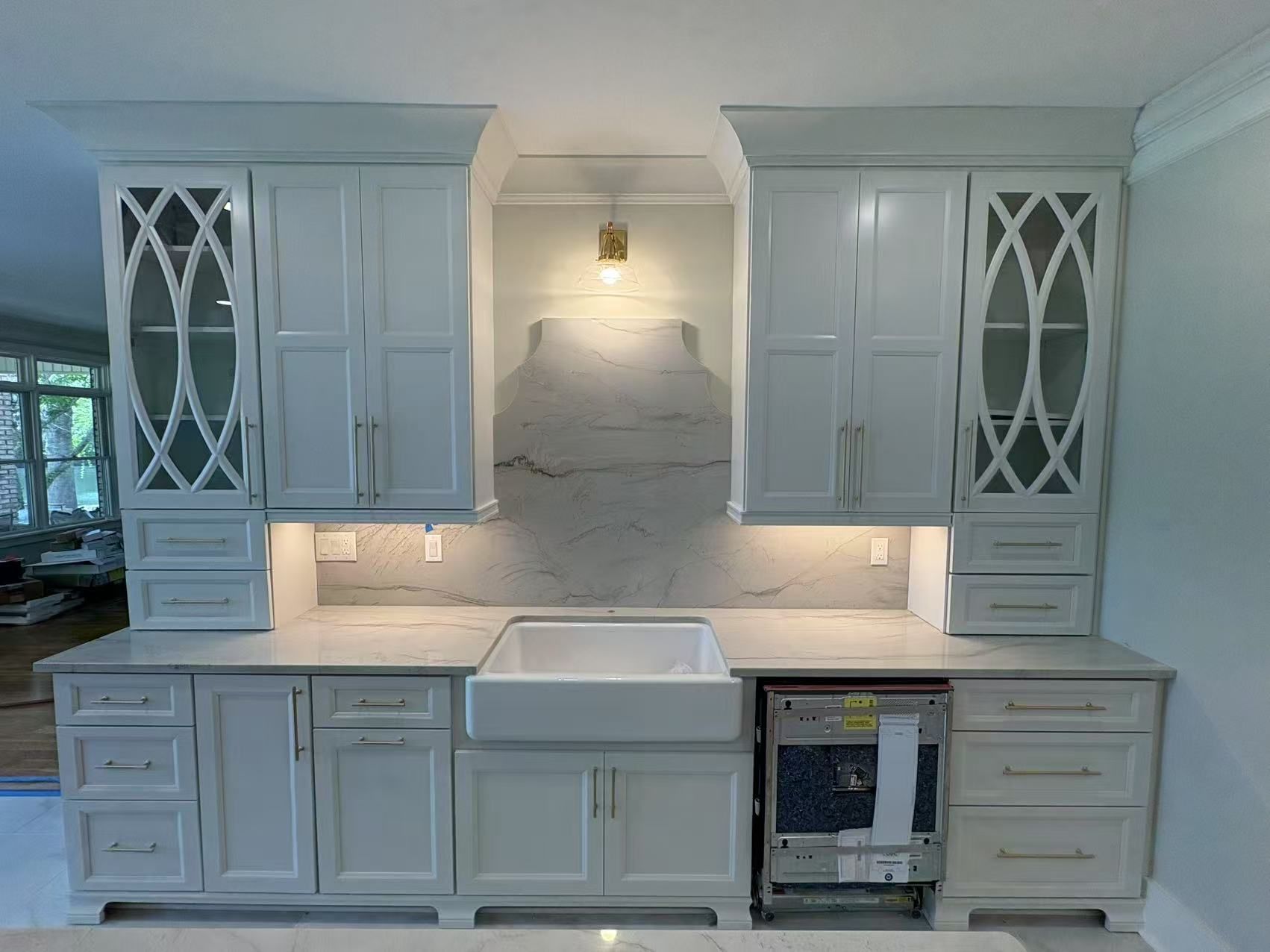A kitchen with white cabinets , a sink , and a refrigerator.