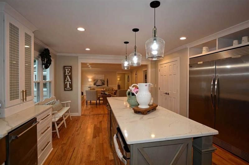 A kitchen with a large island and stainless steel appliances.