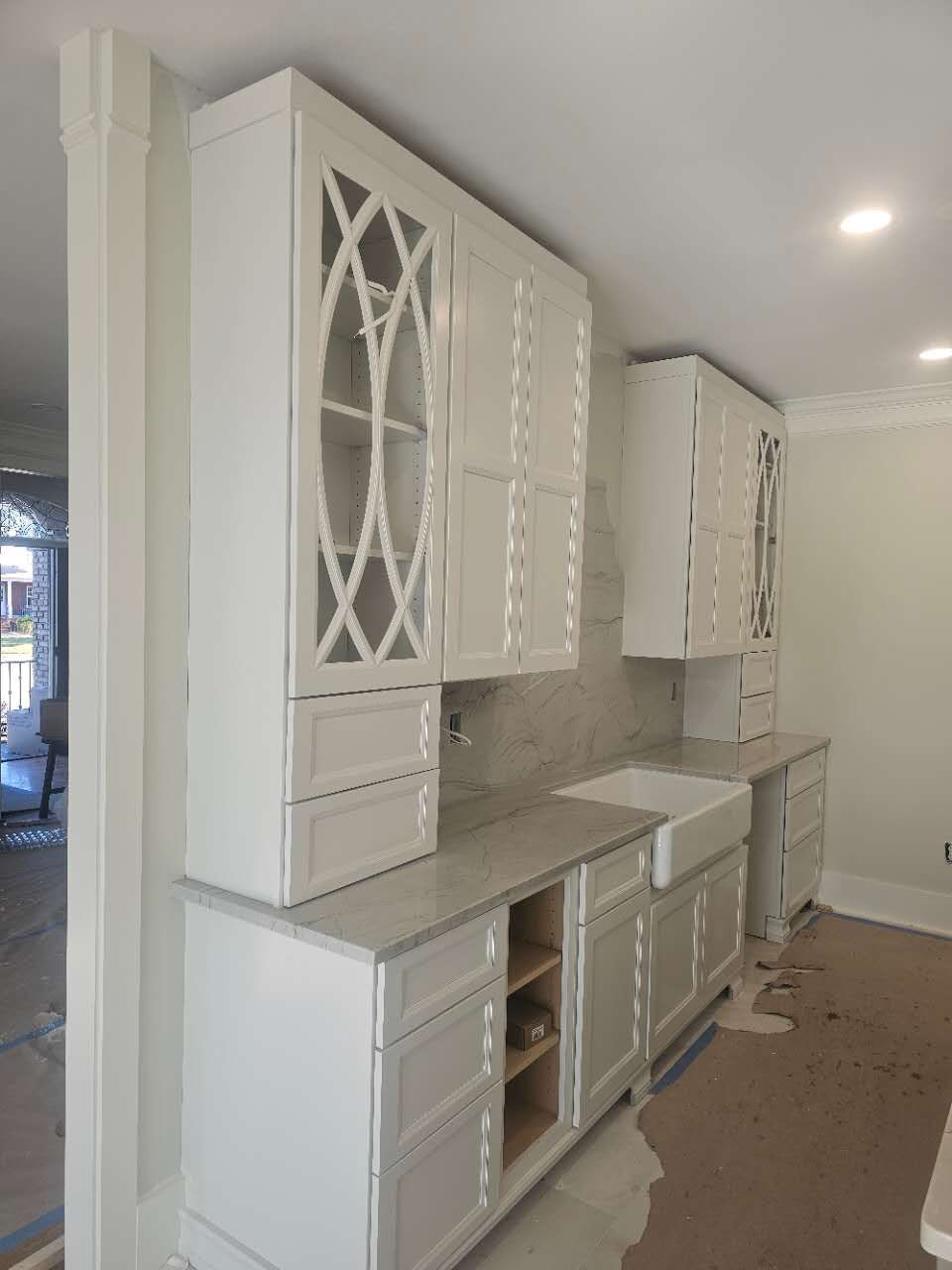A kitchen with white cabinets and a sink.