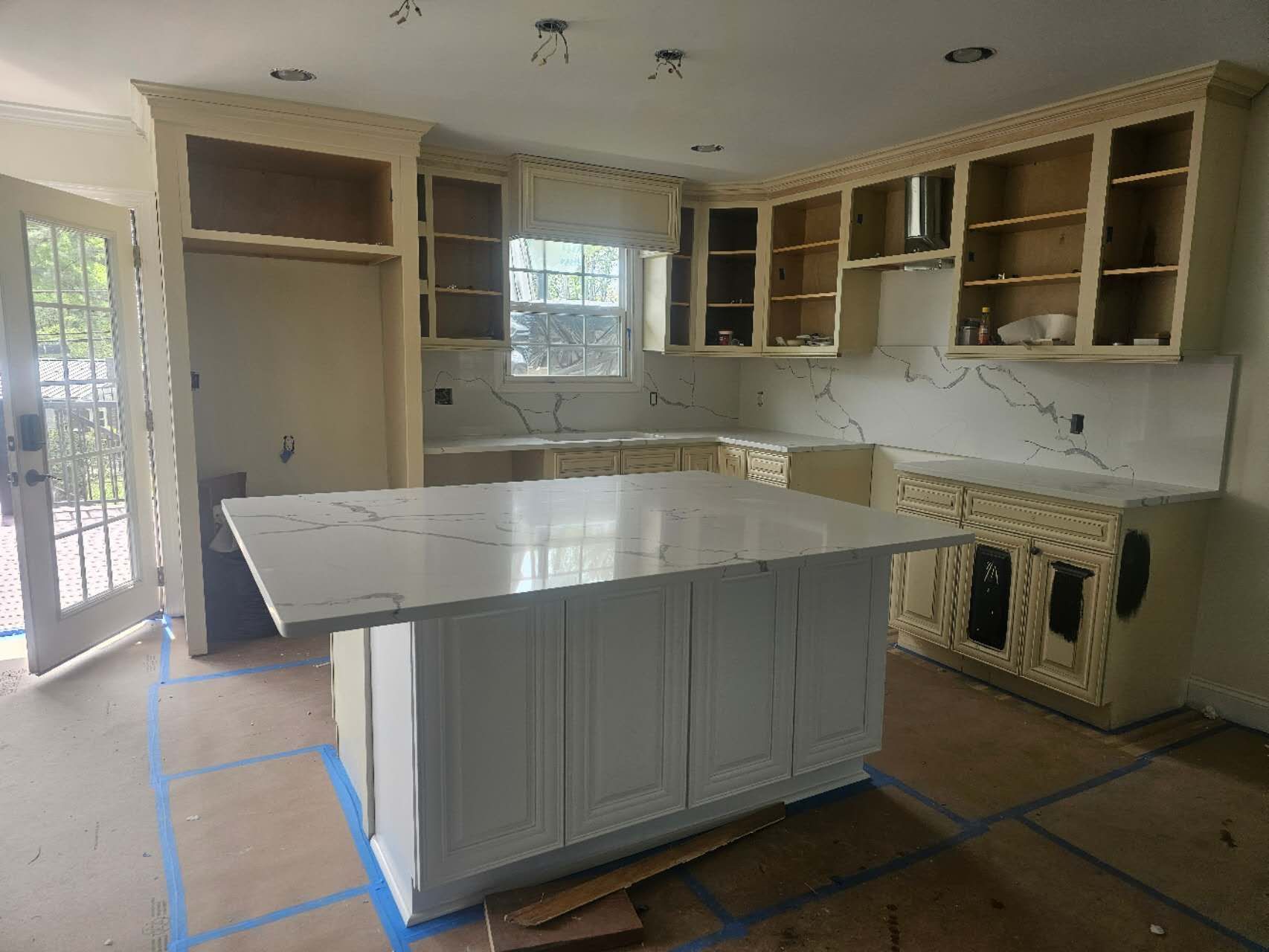 A kitchen under construction with a large island in the middle.