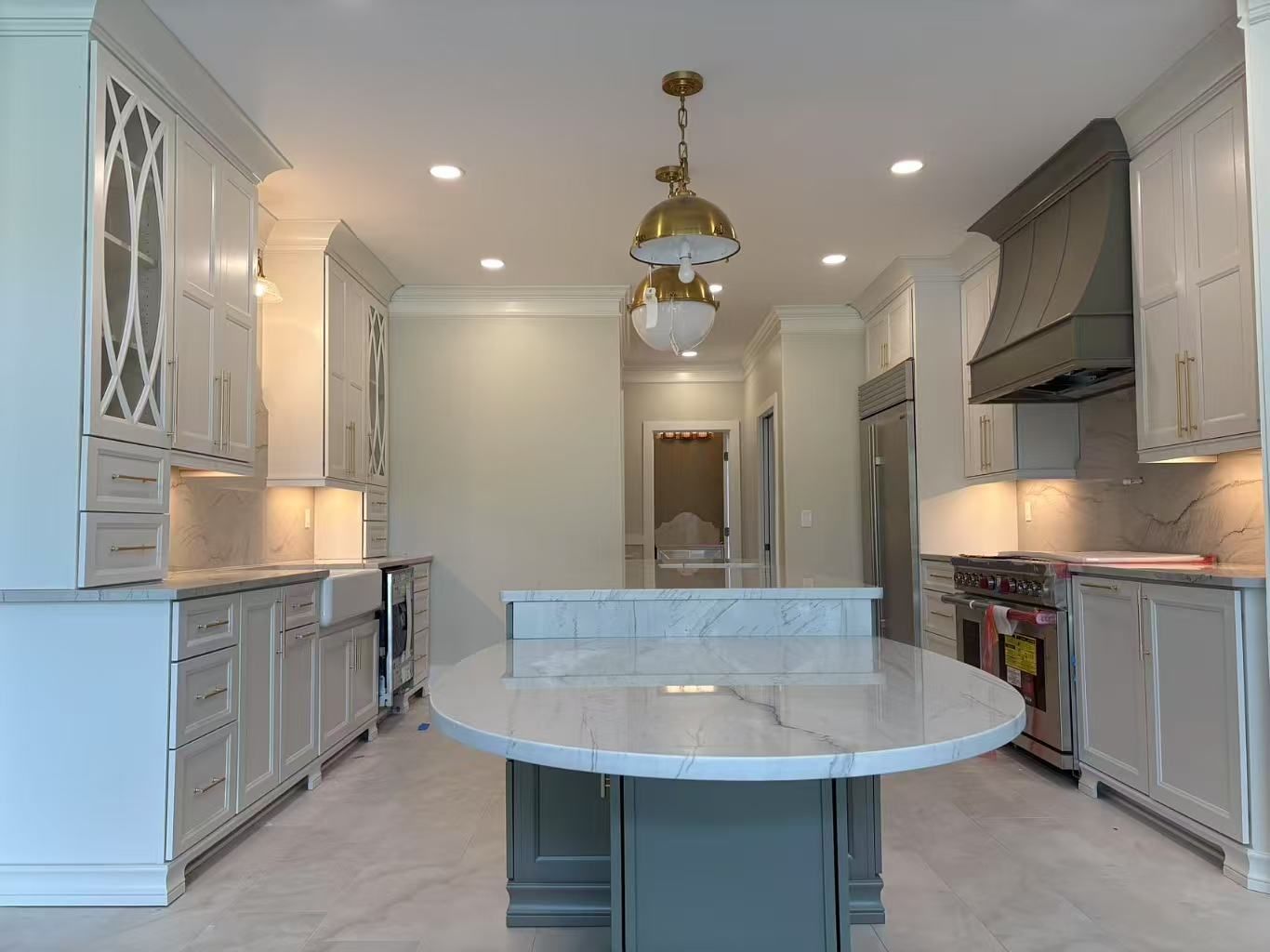 A kitchen with white cabinets and a large island in the middle.