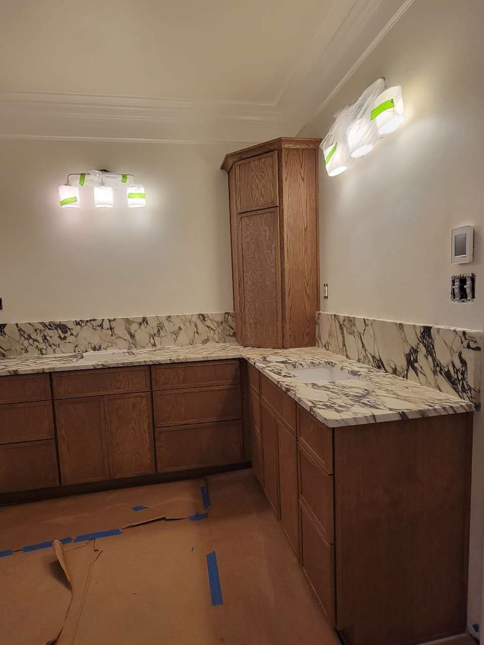 A kitchen with wooden cabinets and marble counter tops is being remodeled.