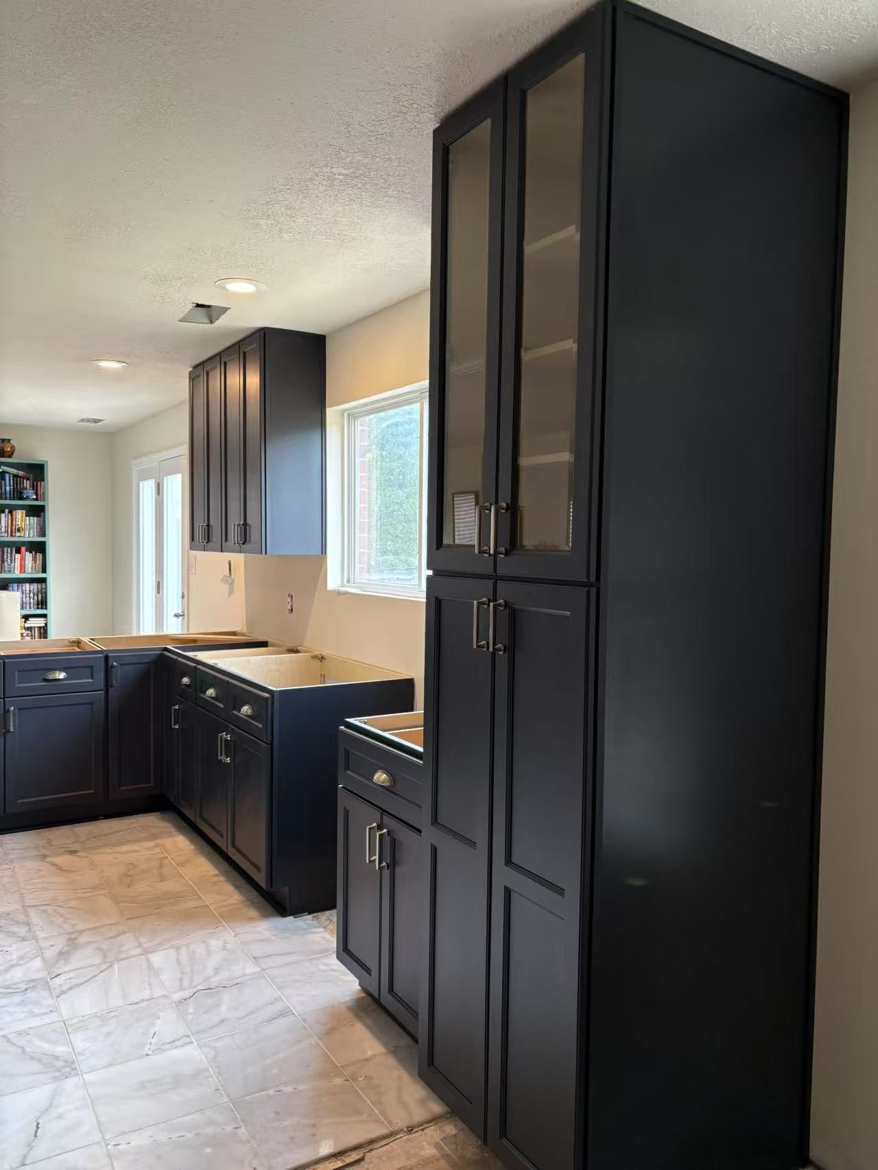A kitchen with black cabinets and a window.