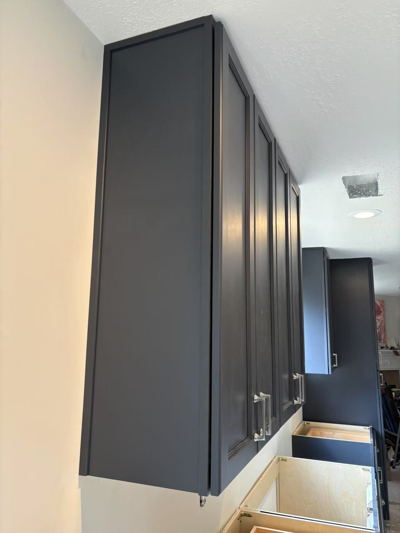 A kitchen with a lot of black cabinets and drawers.