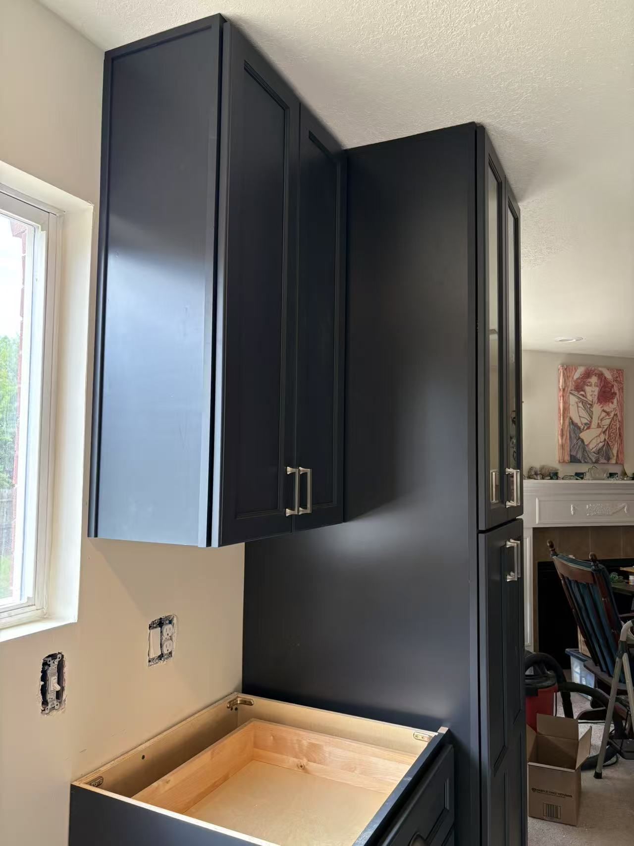 A kitchen with black cabinets and a wooden counter top.