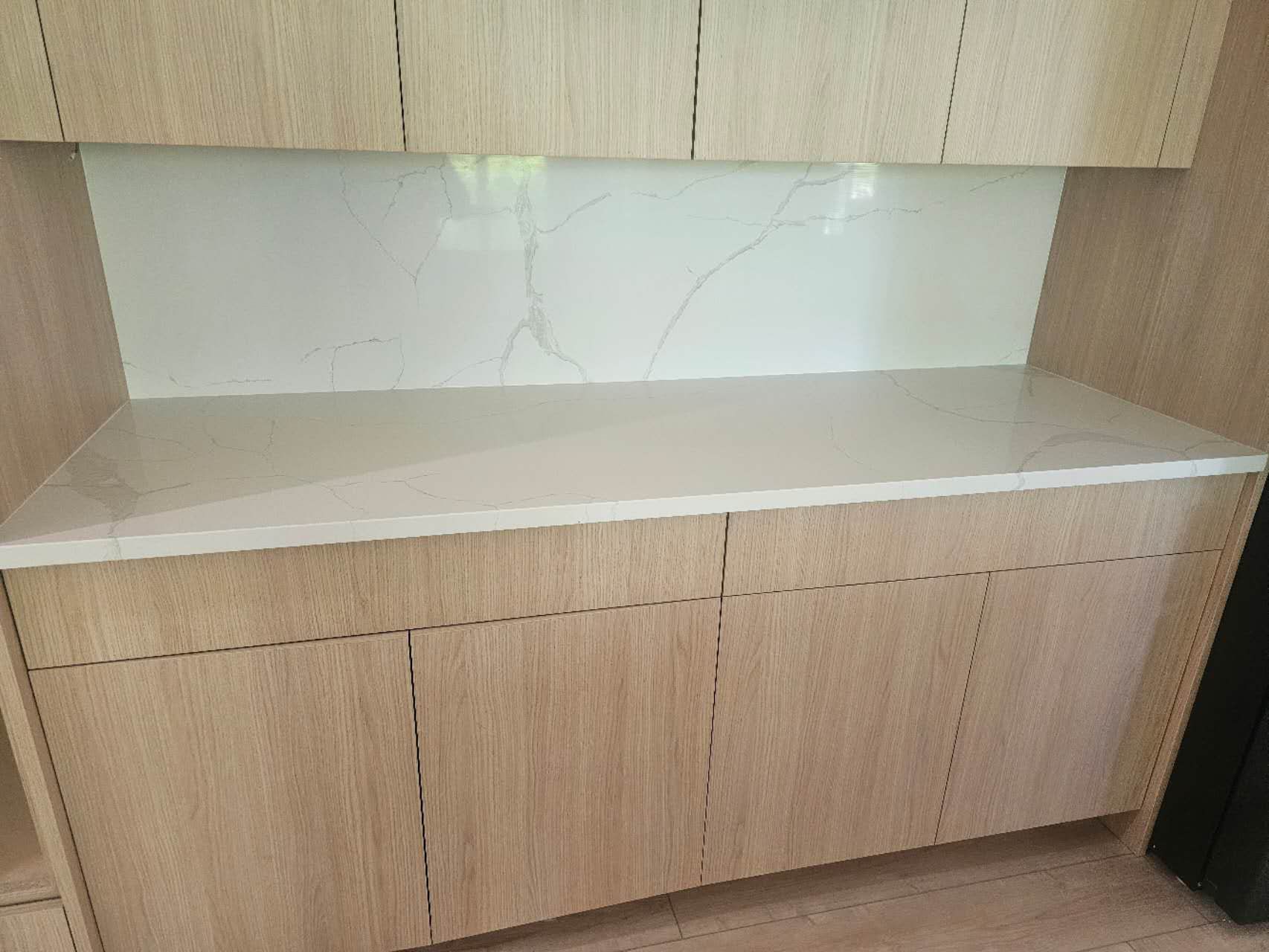 A kitchen with wooden cabinets and a white counter top.