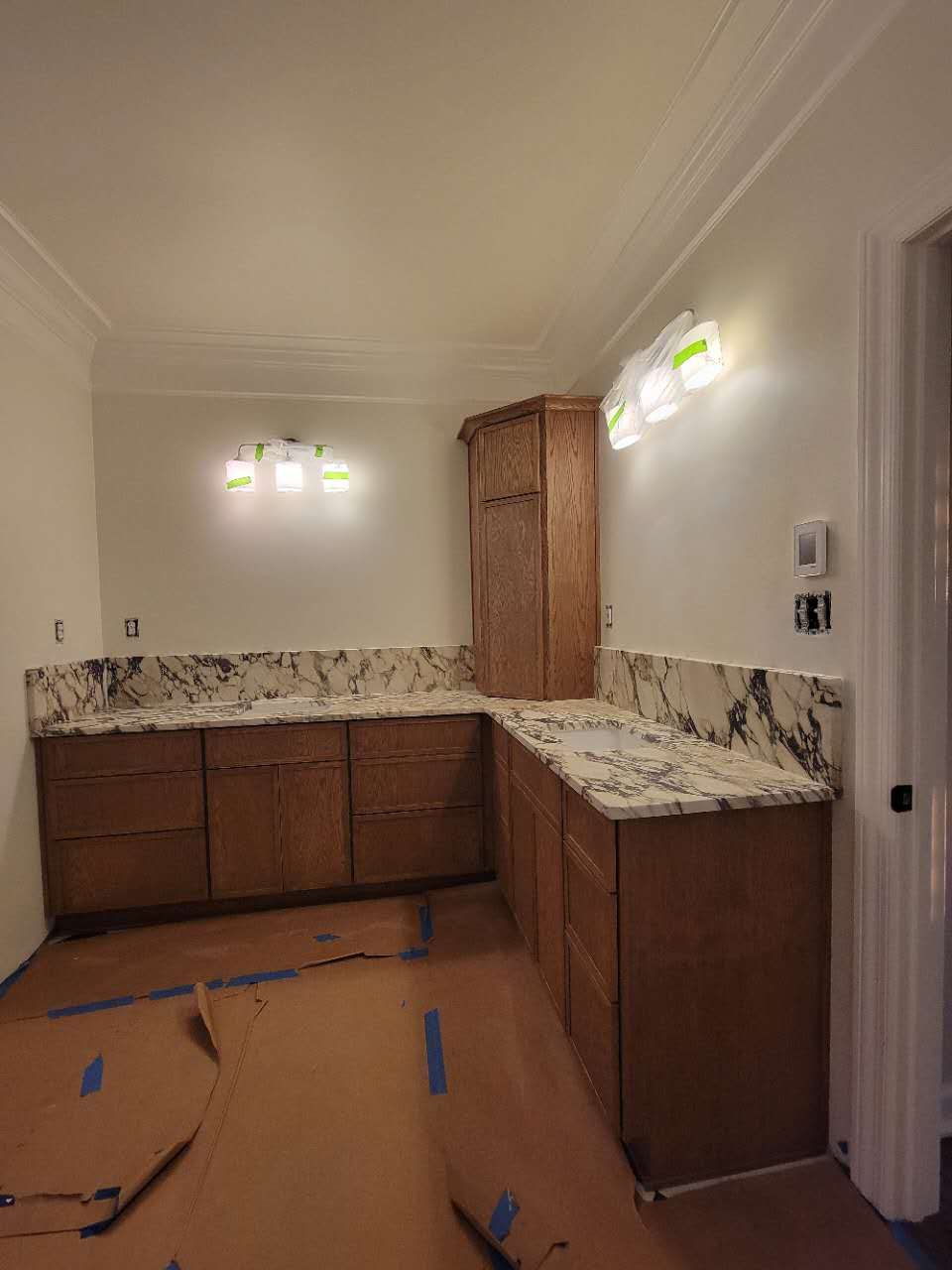 A kitchen with marble counter tops and wooden cabinets is being remodeled.