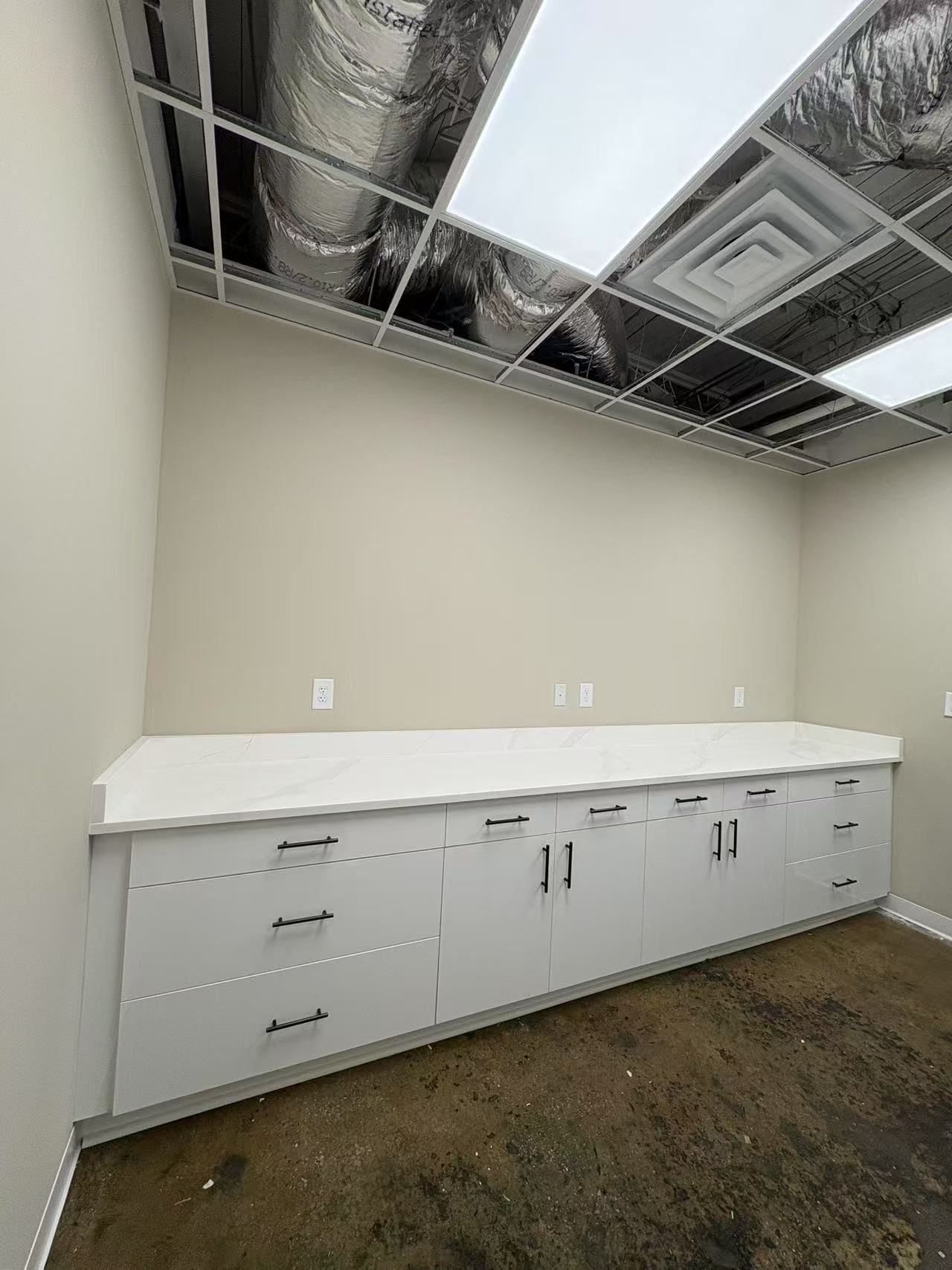 An empty room with white cabinets and a white counter top.