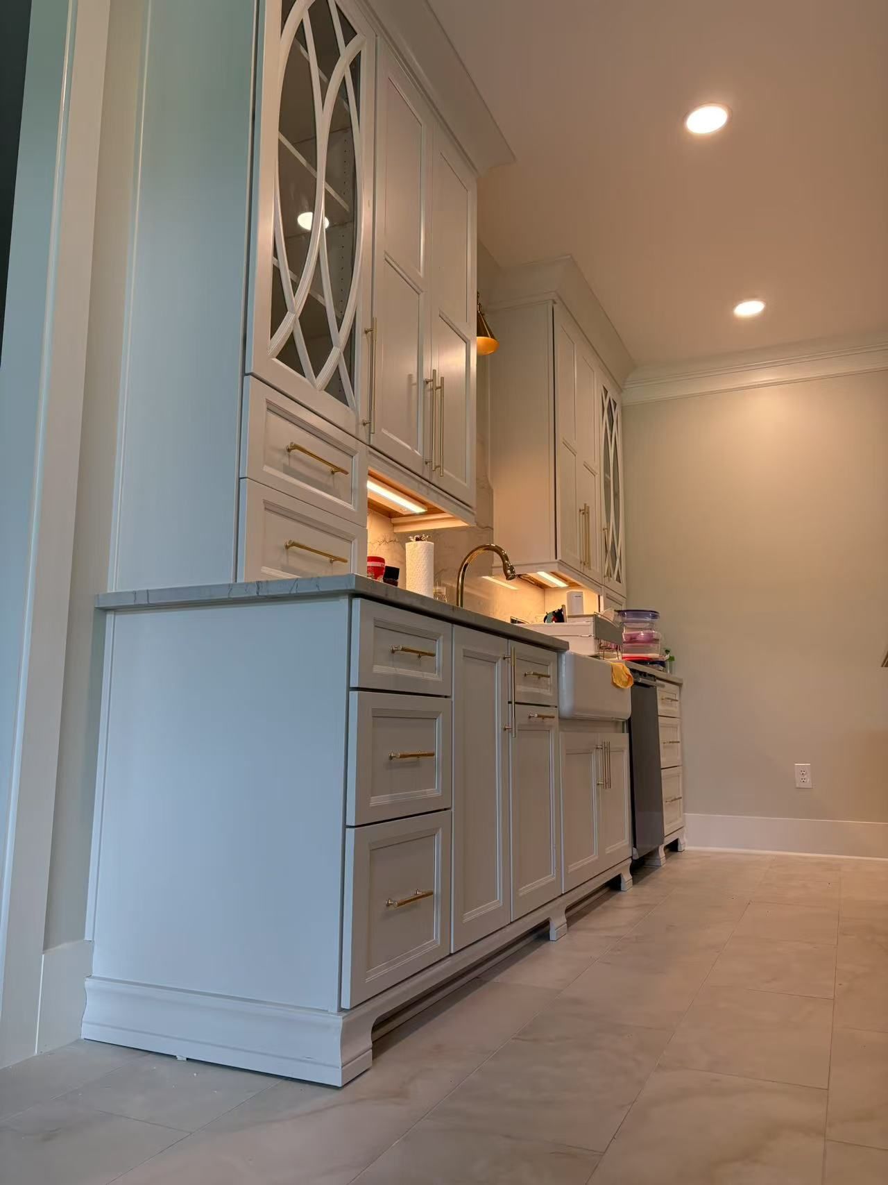 A kitchen with white cabinets and a sink.