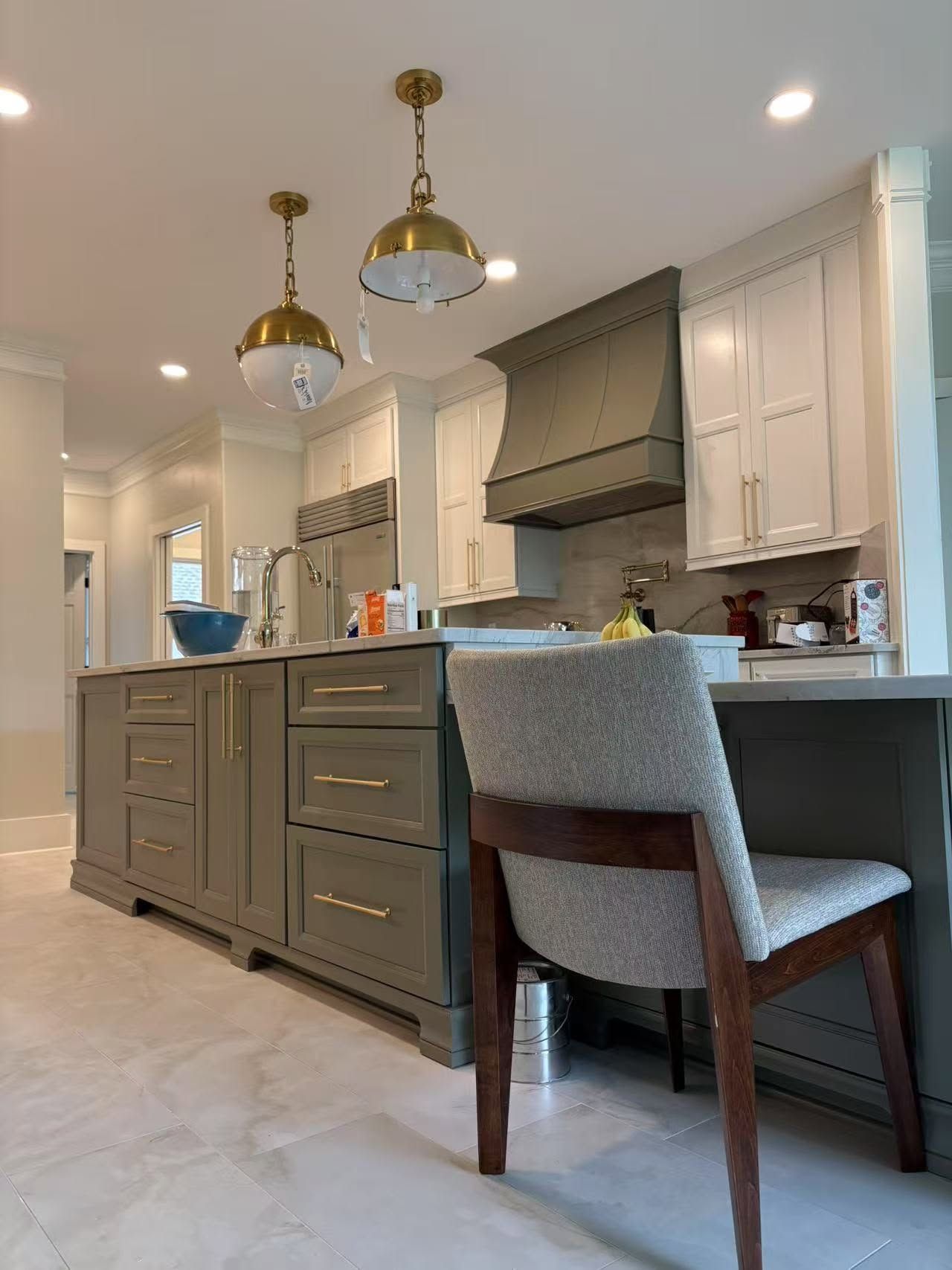 A kitchen with a chair and a desk in it.