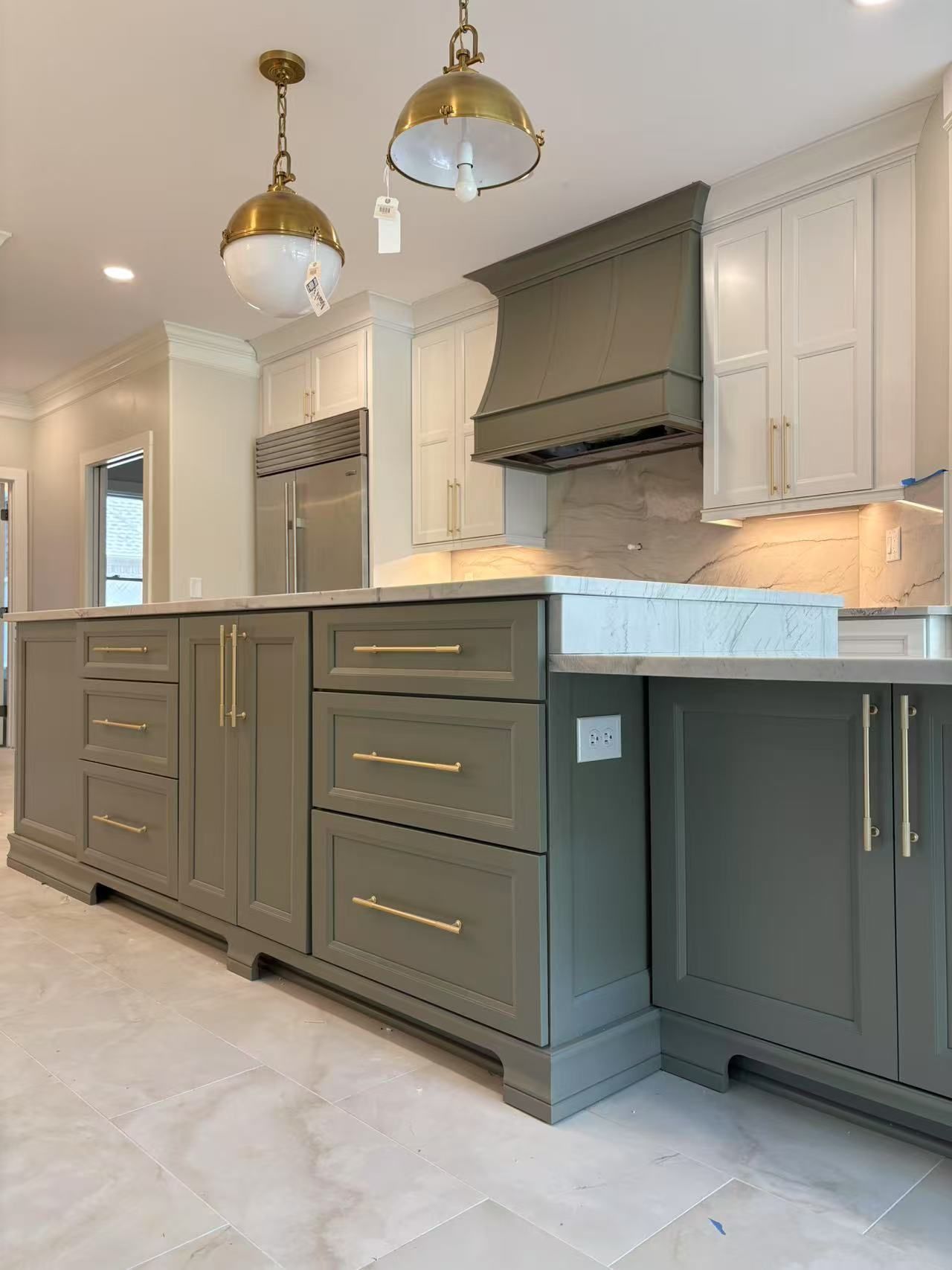 A kitchen with gray cabinets and white counter tops.