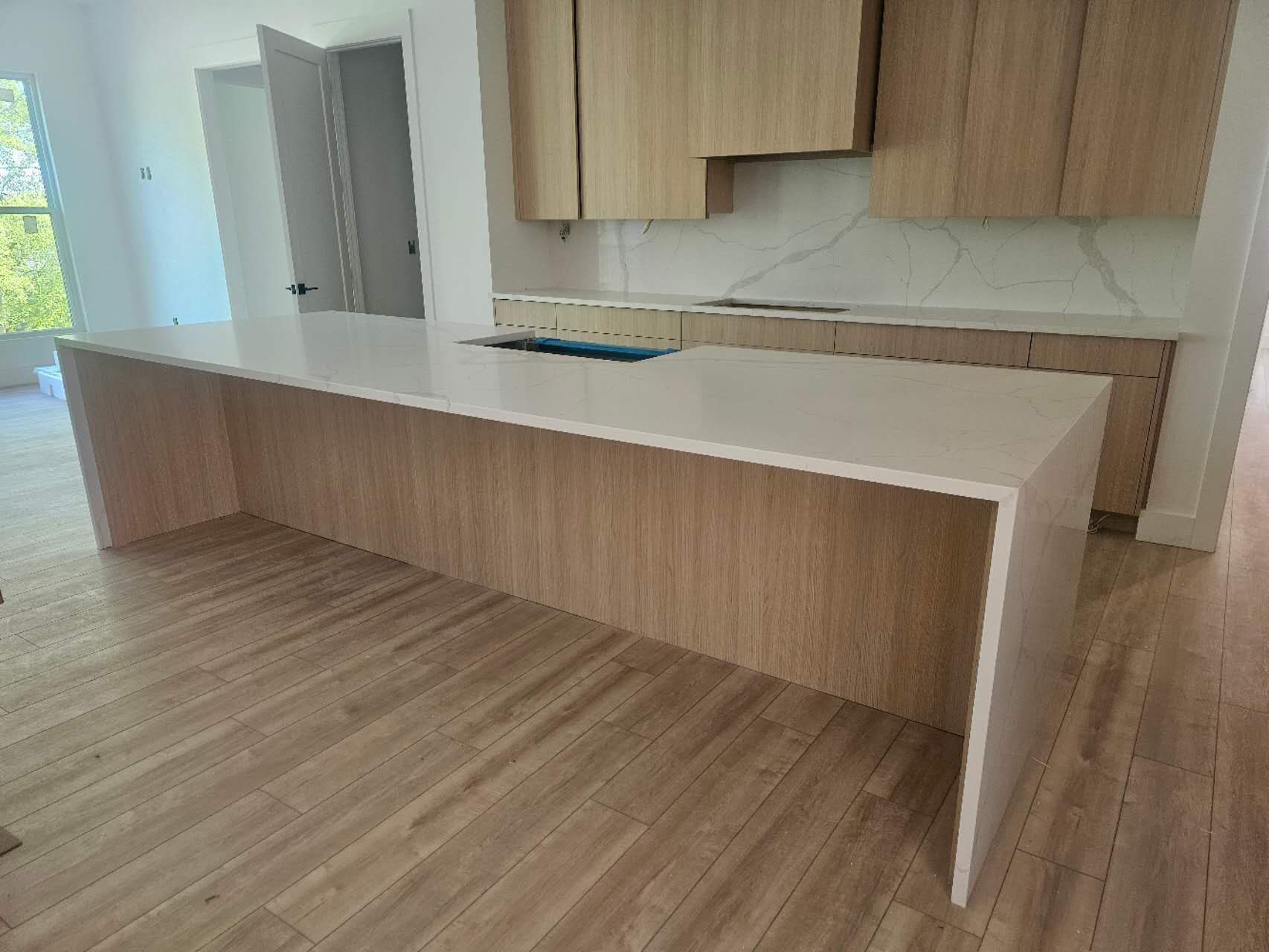 A kitchen with wooden cabinets and white counter tops.