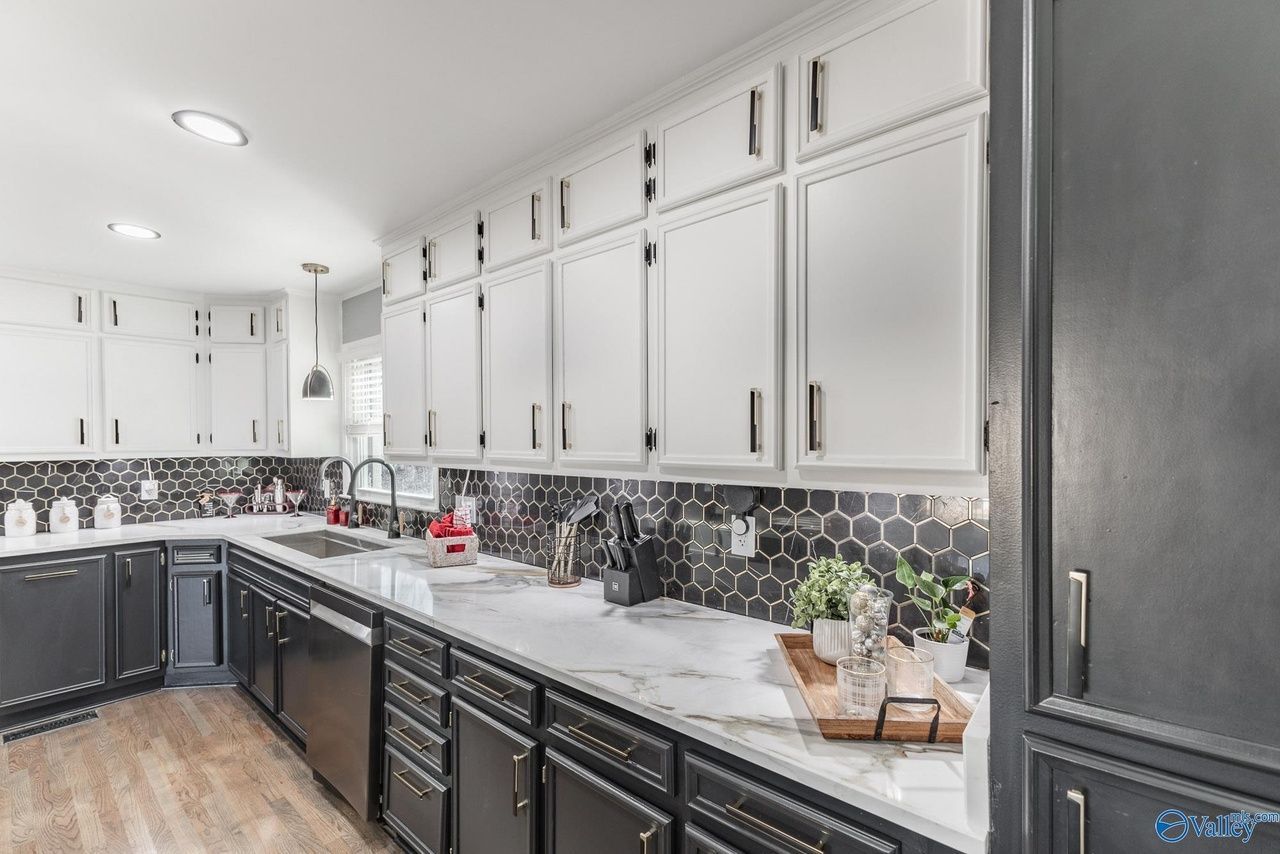 A kitchen with black cabinets and white counter tops.