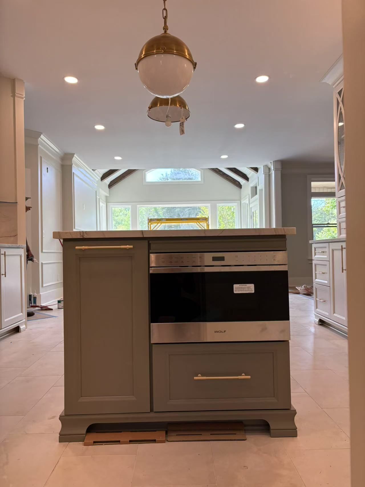 A kitchen with a large island and a stainless steel oven.