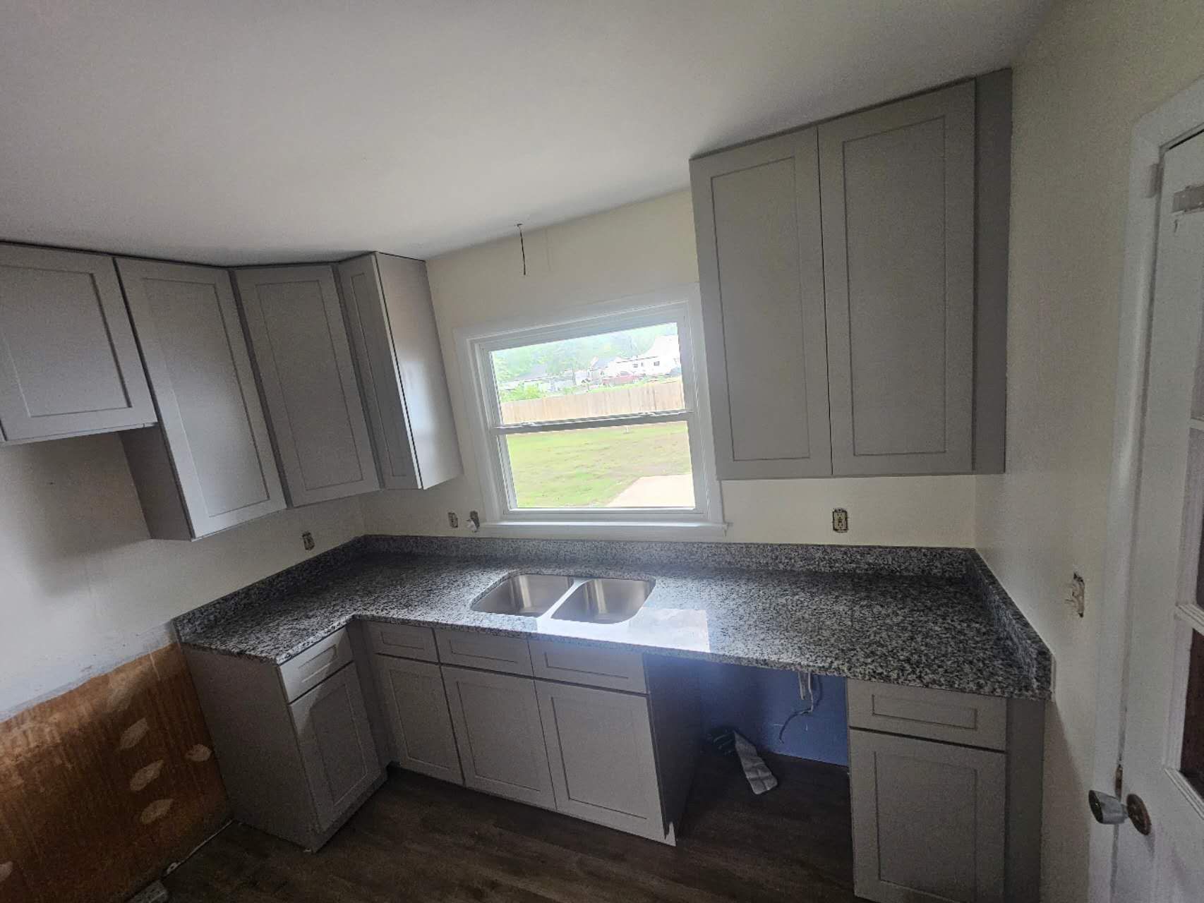 A kitchen with gray cabinets and granite counter tops.