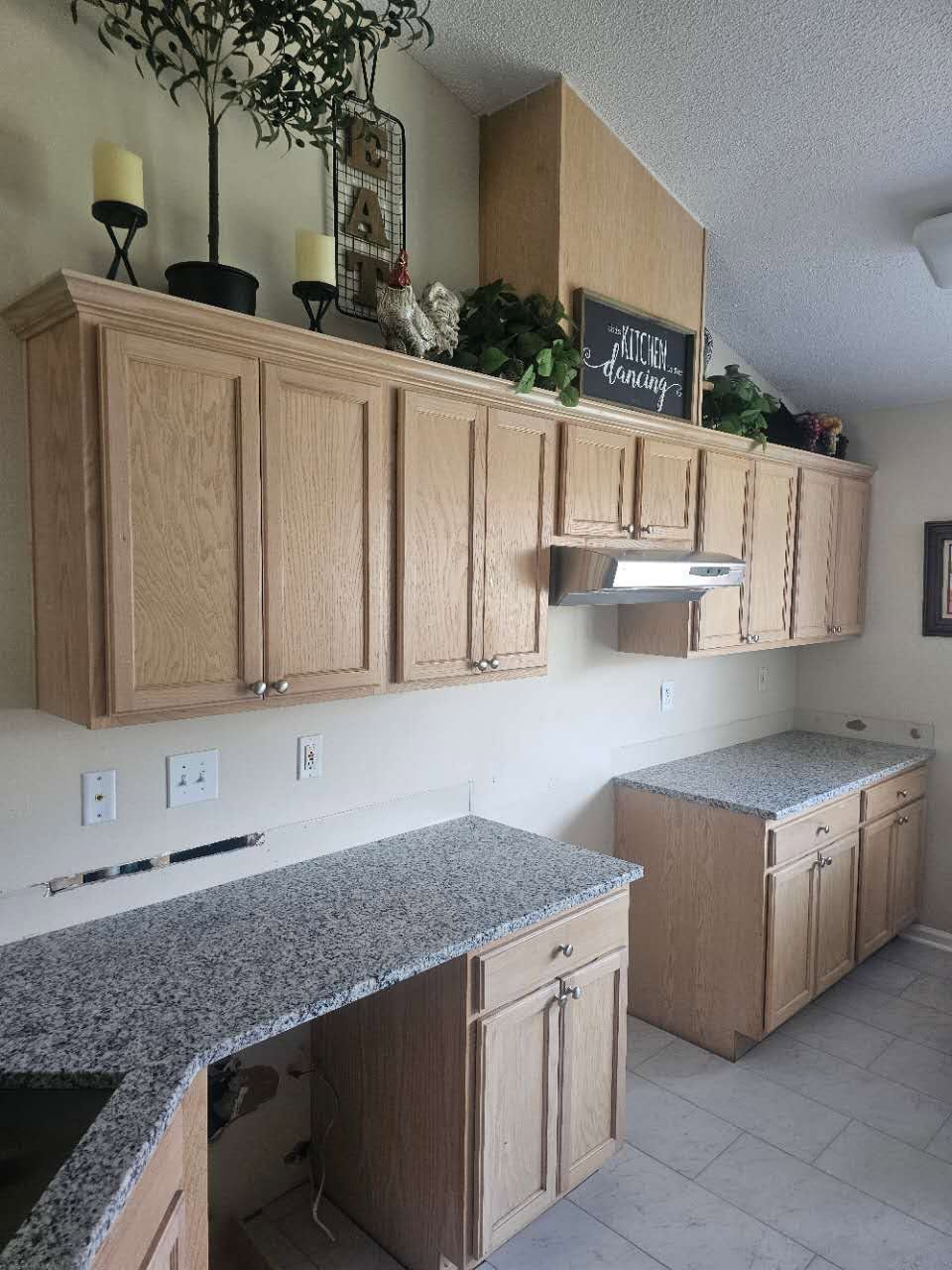 A kitchen with wooden cabinets and granite counter tops.