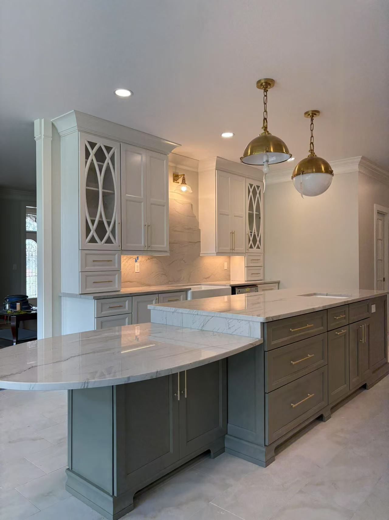 A kitchen with a large island and marble counter tops.