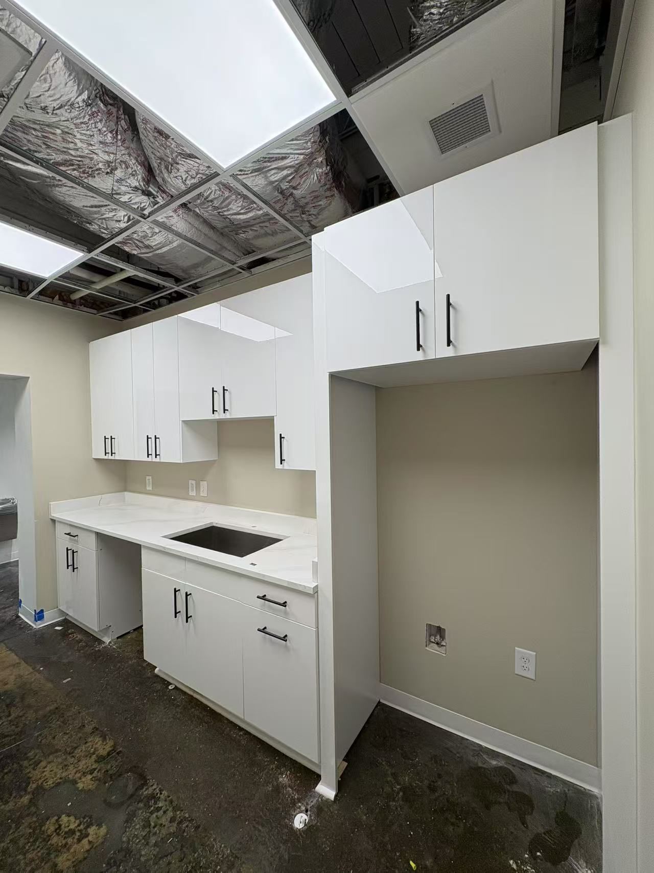 A kitchen with white cabinets and a black stove top oven.