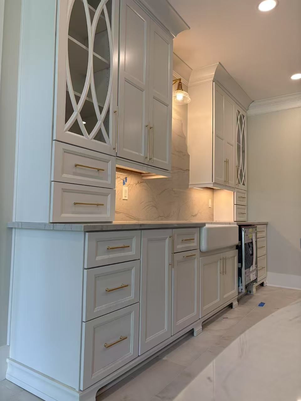 A kitchen with white cabinets, drawers, and a sink.
