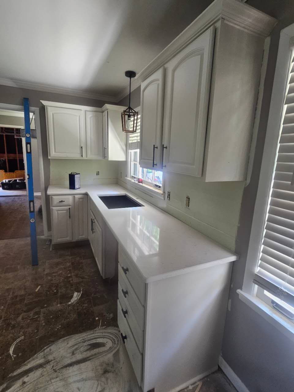 A kitchen with white cabinets and white counter tops.