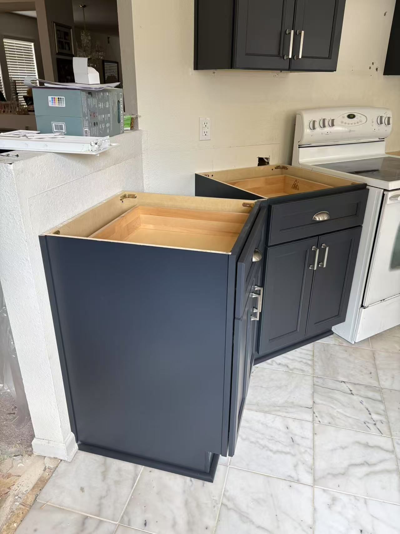 A kitchen with black cabinets and a white stove.
