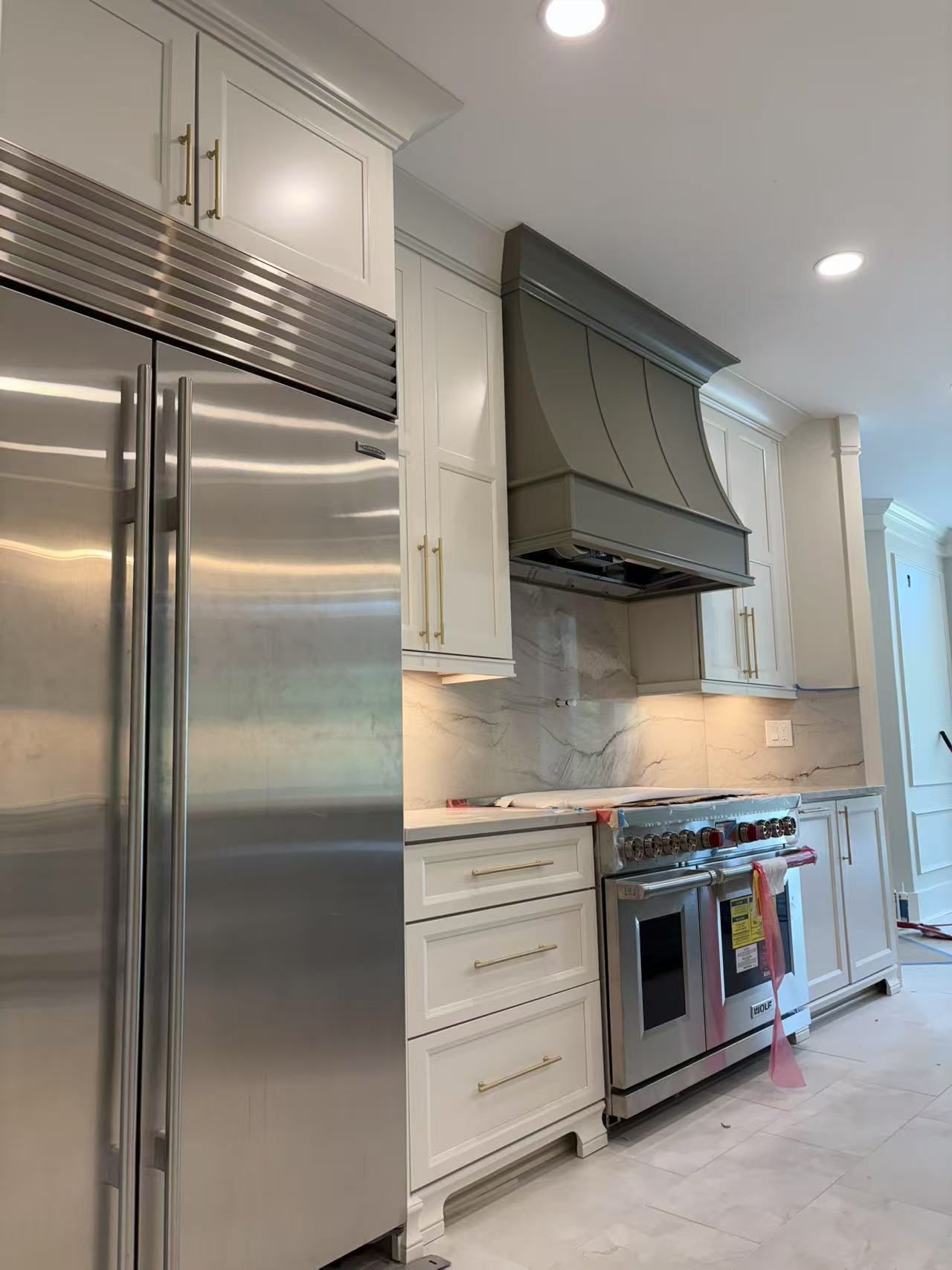 A kitchen with stainless steel appliances and white cabinets.