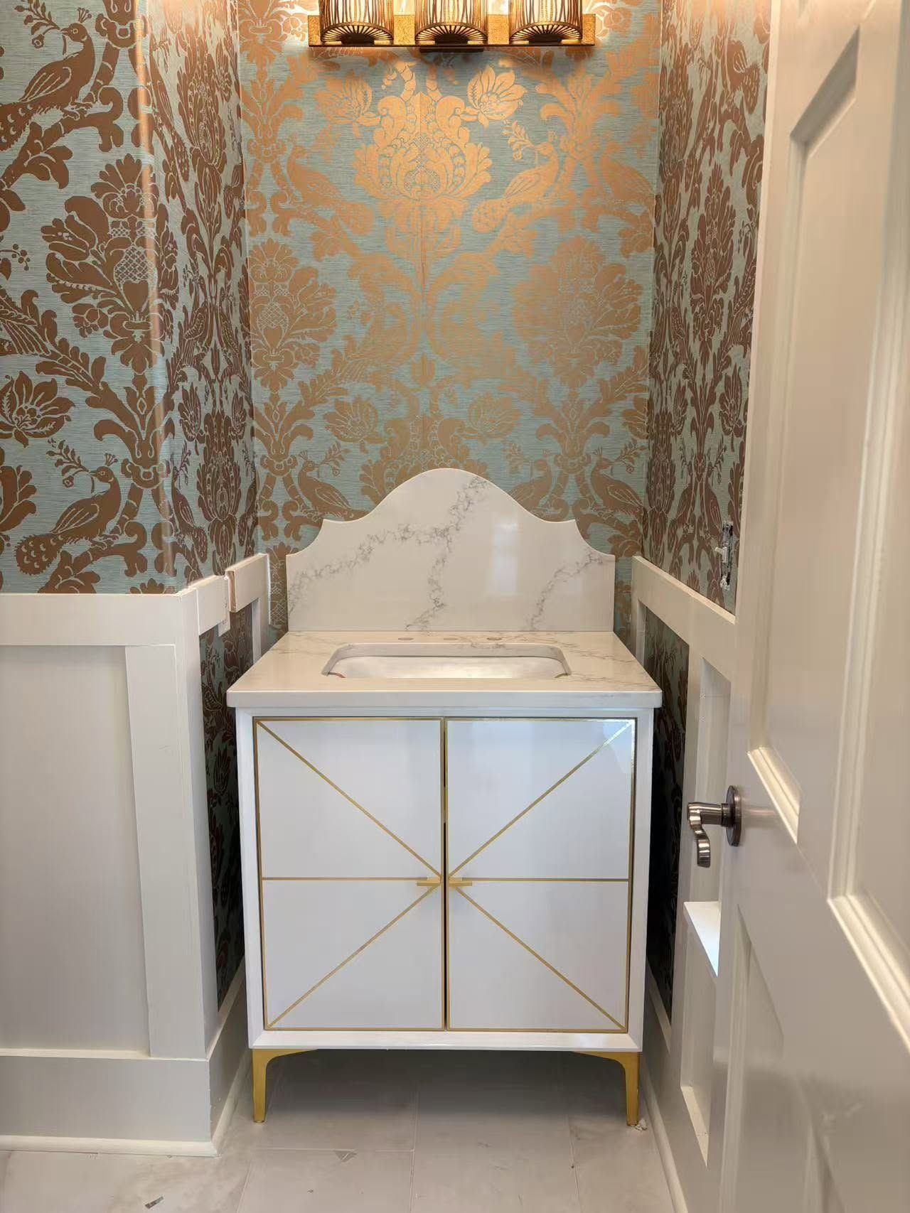 A bathroom with a sink and a light on the wall.