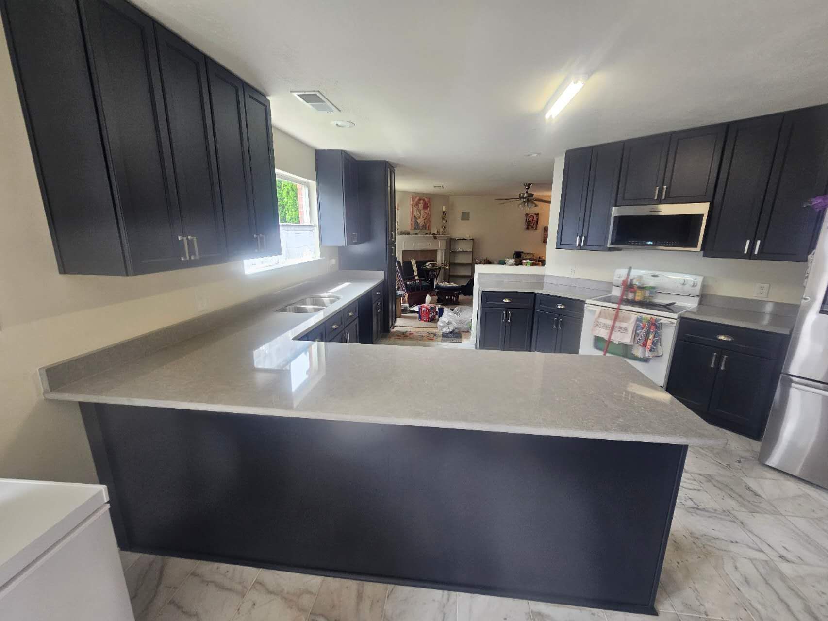 A kitchen with black cabinets and granite counter tops.
