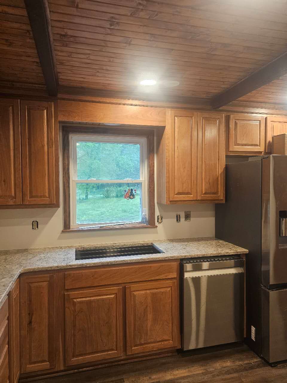 A kitchen with stainless steel appliances and wooden cabinets.