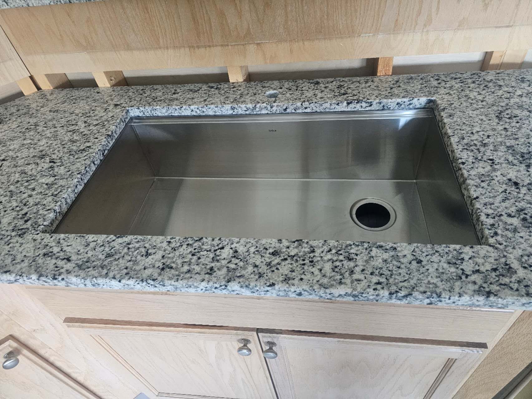 A stainless steel sink is sitting on top of a granite counter top.