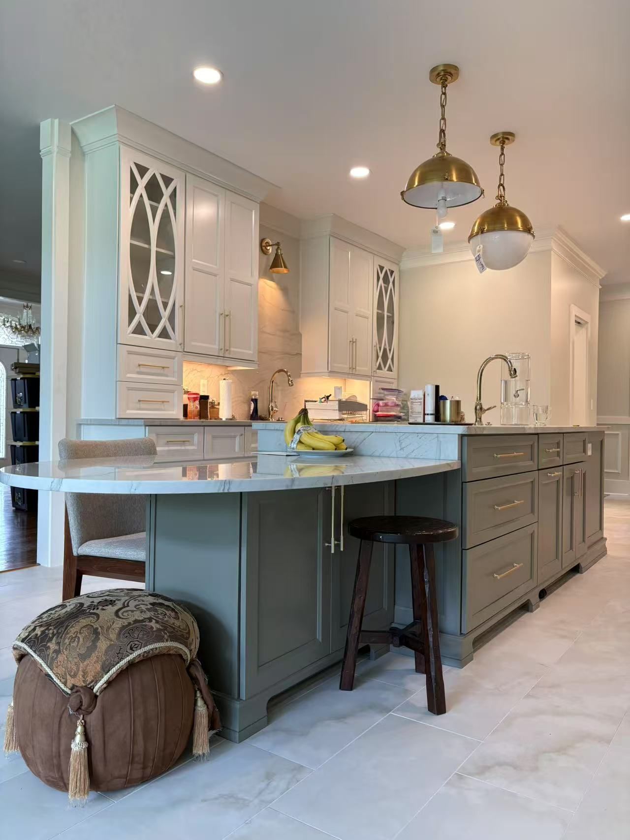 A kitchen with a large island and a stool in the middle.
