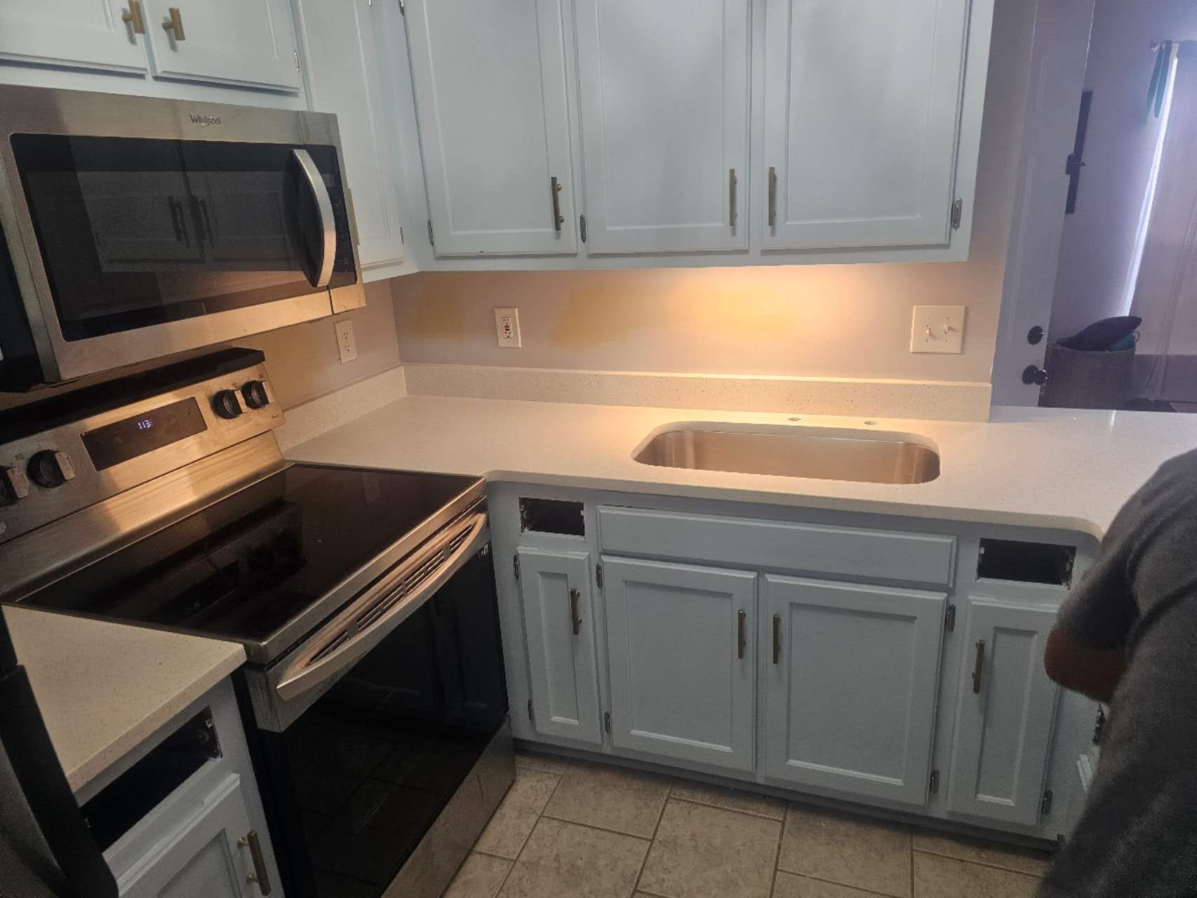 A kitchen with white cabinets, stainless steel appliances, and a sink.