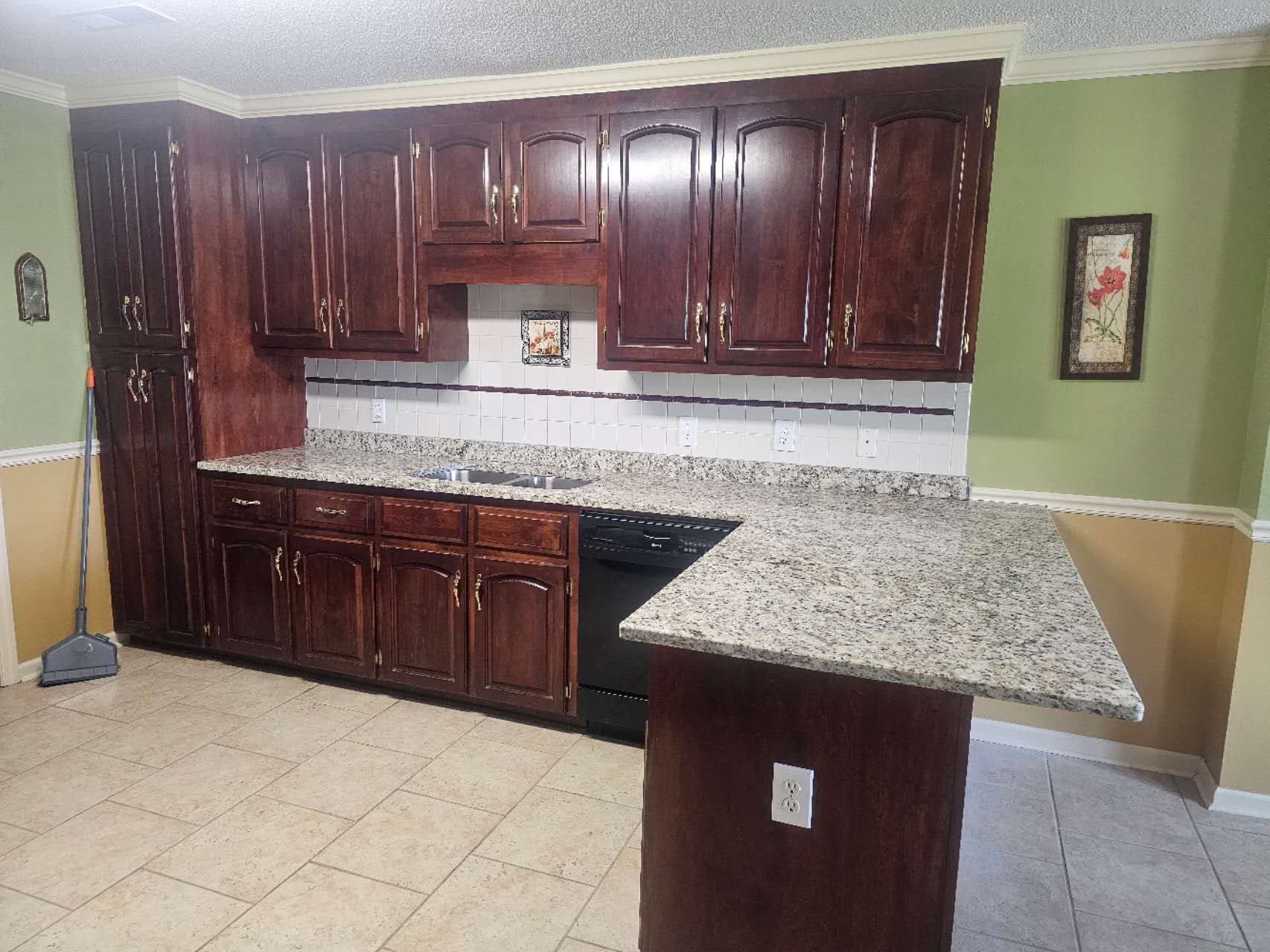 A kitchen with wooden cabinets and granite counter tops.